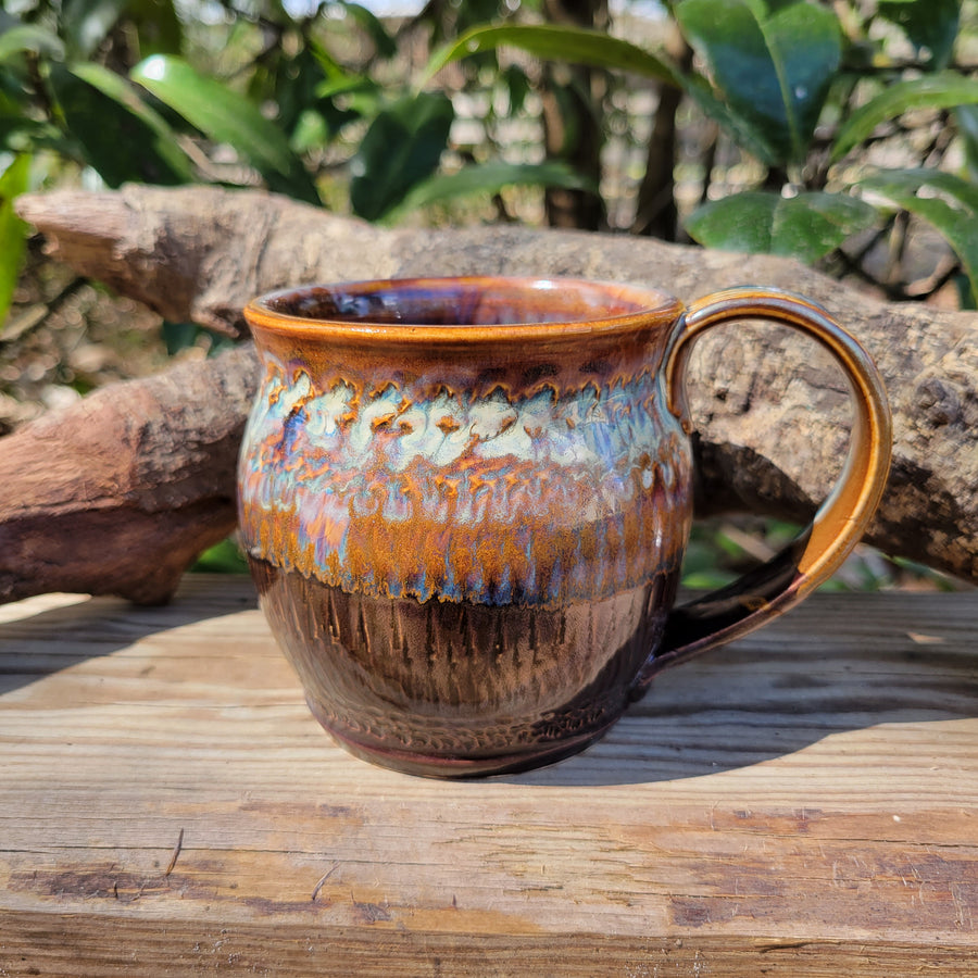 Mug glazed with dark brown and gold/blue accents