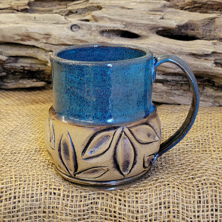 Mug is glazed with a deep indigo blue and iron wash applied on carved texture