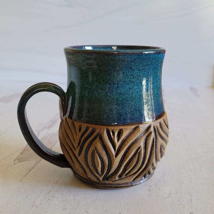 Carved mug is glazed with an indigo blue glaze