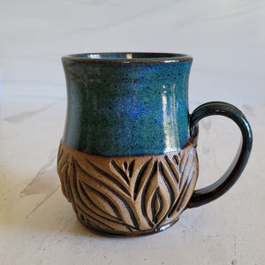 Carved mug is glazed with an indigo blue glaze