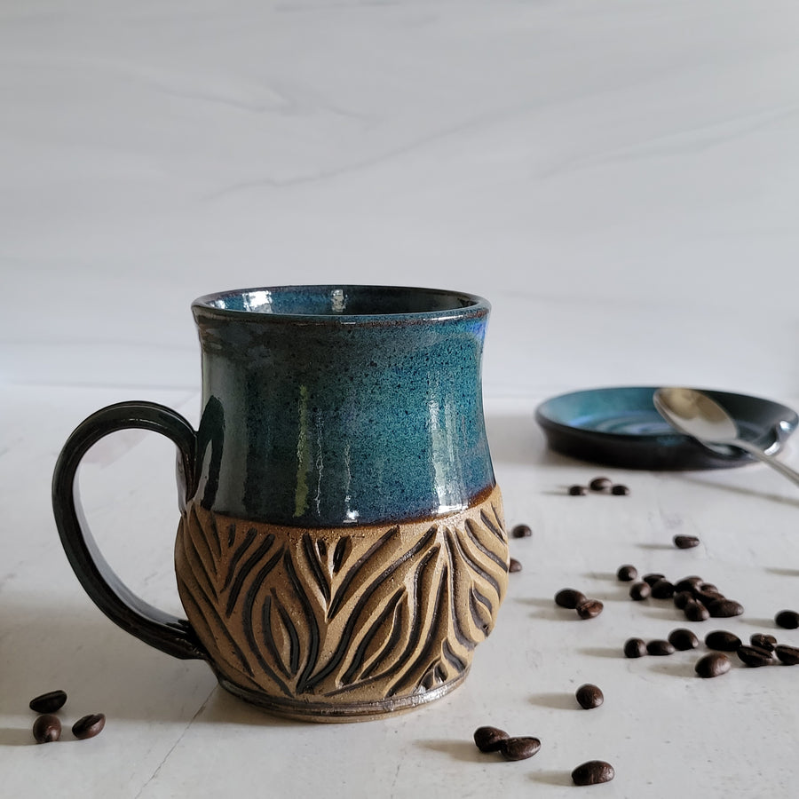 Carved mug is glazed with an indigo blue glaze