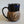 Load image into Gallery viewer, Carved mug is glazed with an obsidian glaze with blue accents on the rim
