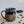 Load image into Gallery viewer, Carved mug is glazed with an obsidian glaze and cream accenting the rim.
