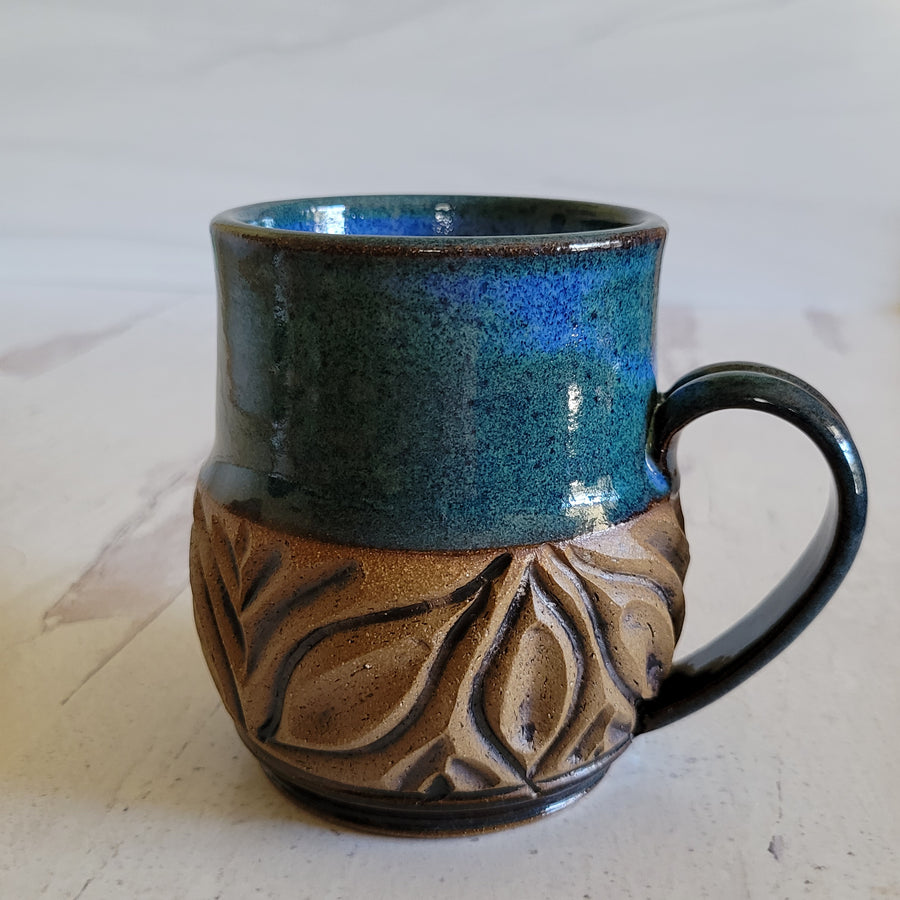 Carved mug is glazed with an indigo blue glaze.