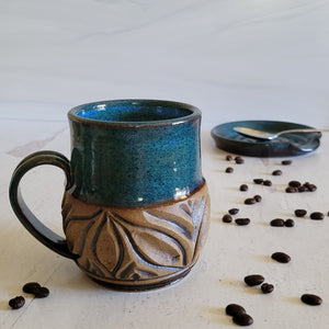 Carved mug is glazed with an indigo blue glaze.