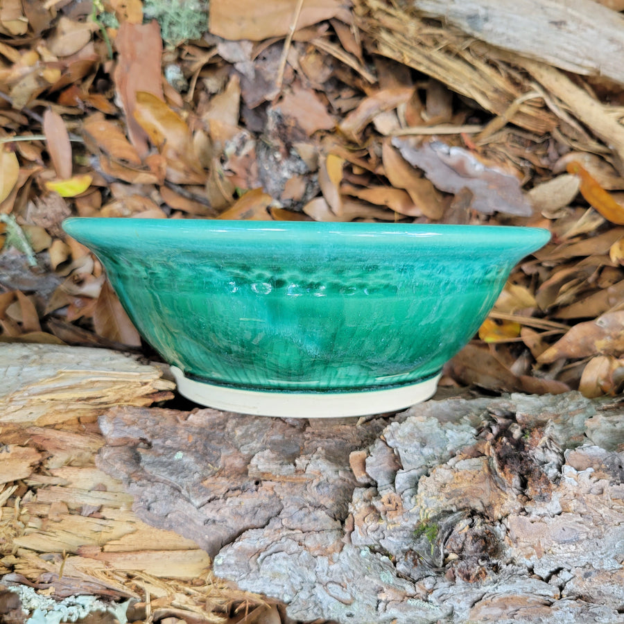 Wheel thrown bowl with cream interior and celadon glaze and muted chatter texture on exterior_side view
