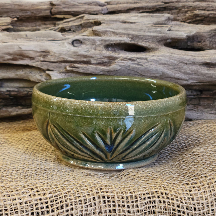 Wheel thrown carved bowl with blue celadon glaze with additional blue-green accents