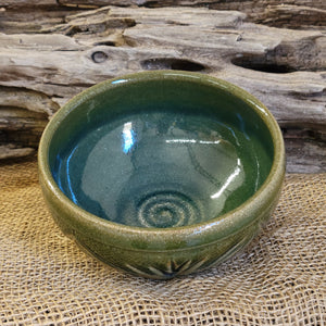 Wheel thrown carved bowl with blue celadon glaze with additional blue-green accents