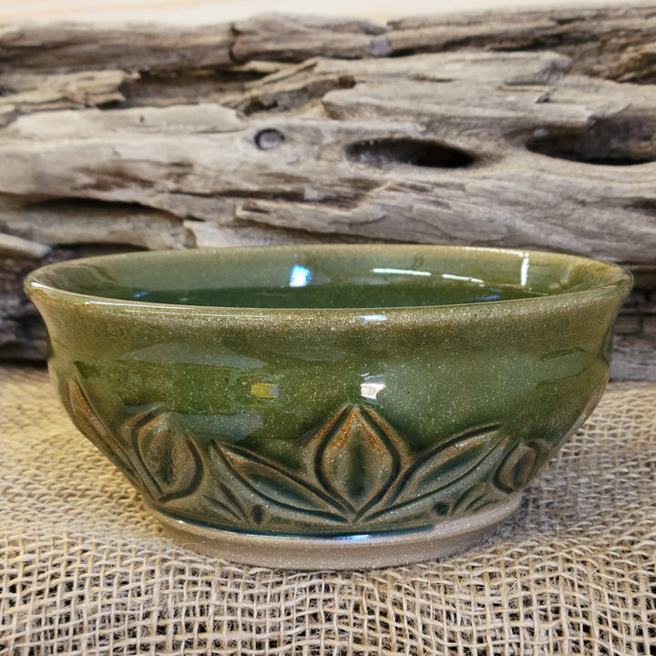 Wheel thrown carved bowl has a blue celadon glaze with additional blue-green accents