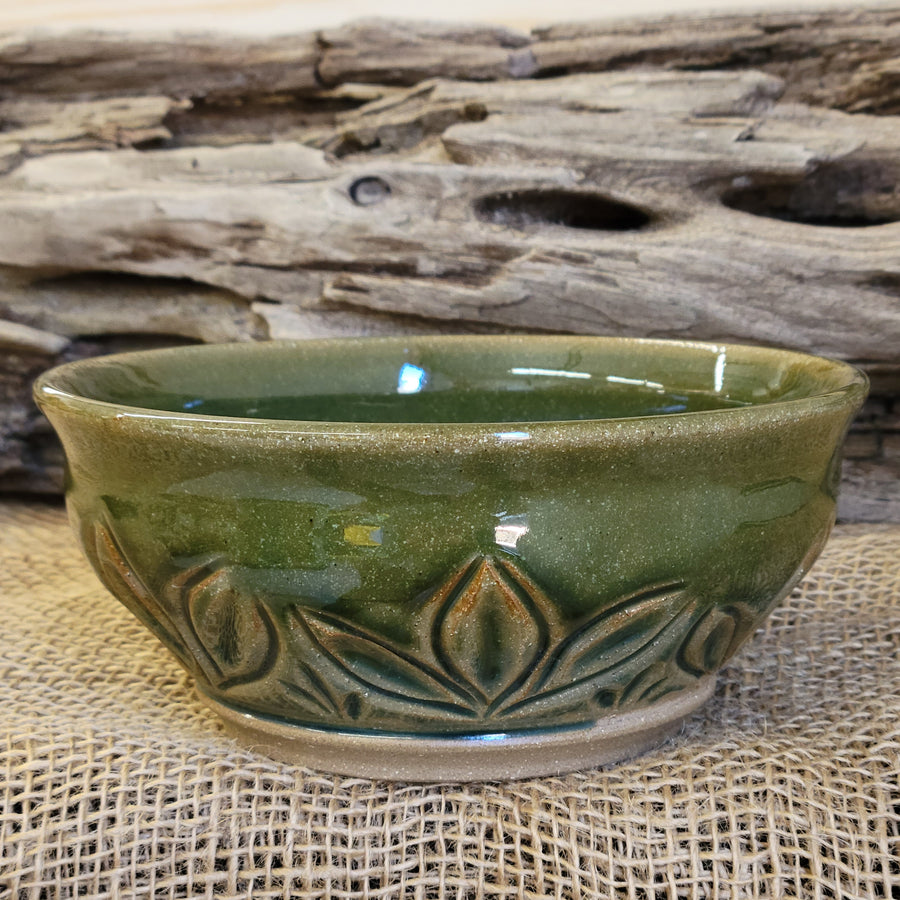 Wheel thrown carved bowl has a blue celadon glaze with additional blue-green accents