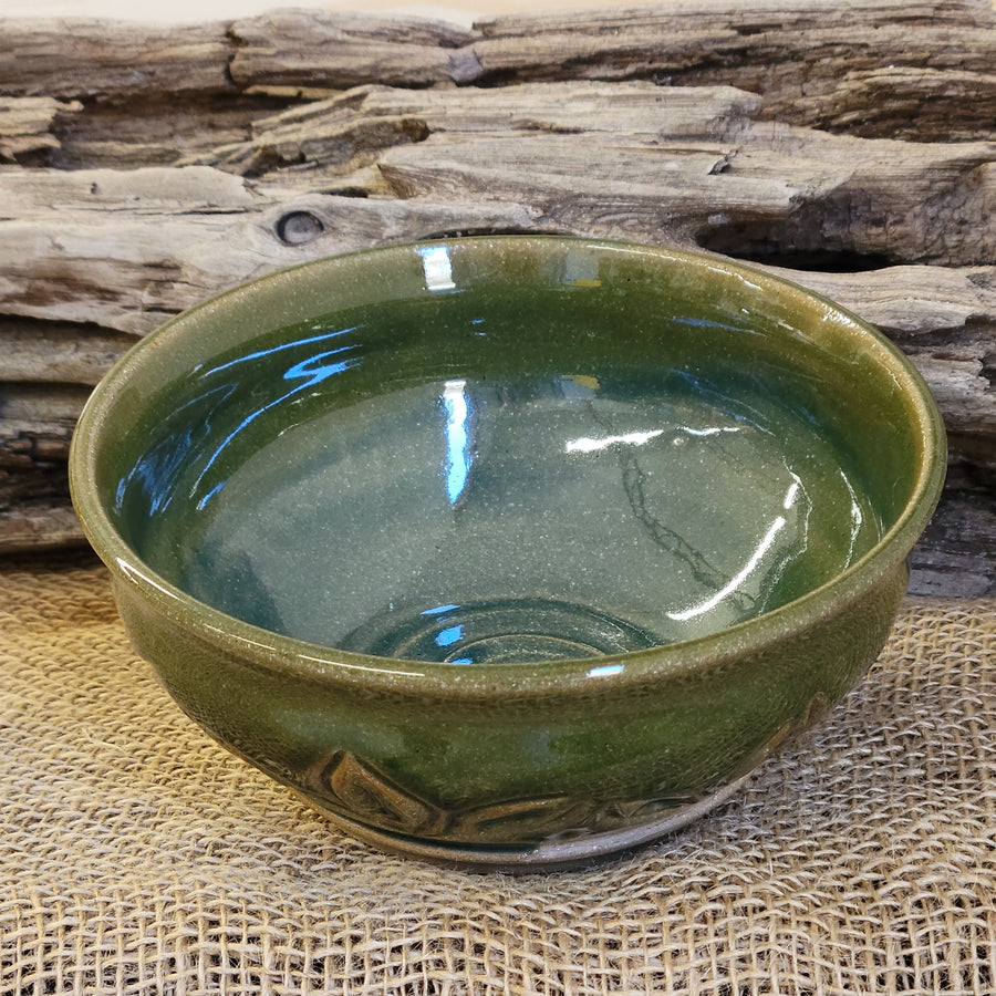 Wheel thrown carved bowl has a blue celadon glaze with additional blue-green accents