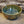 Load image into Gallery viewer, Wheel thrown bowl has a blue celadon glaze with additional blue-green and brown accents
